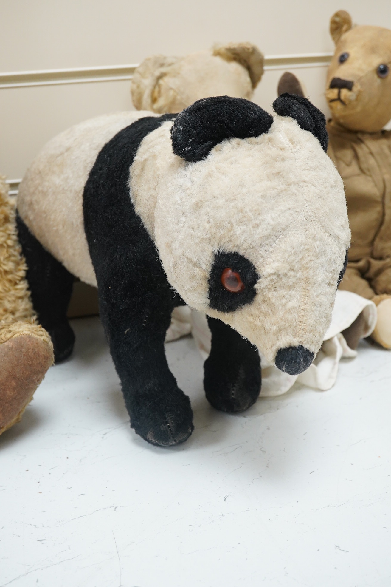 A Panda Invicta bear cotton plush, damage to paw pads, a Merrythought Panda, two other English bears (4). Condition - poor.